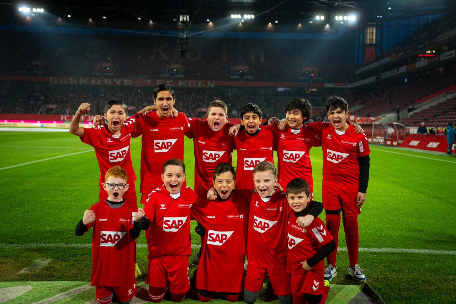 Die AG „Kicken und Lesen“ stellt einen Fahnenjungen beim Heimspiel des 1.FC Köln
